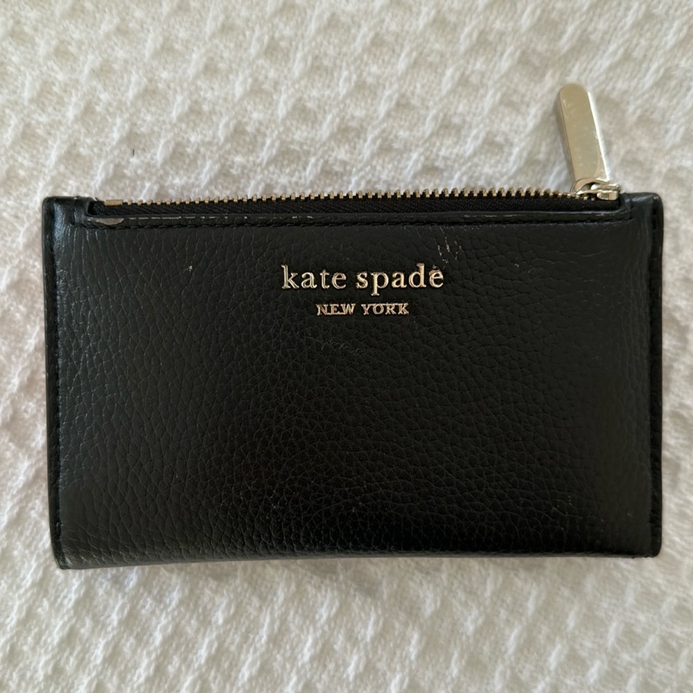 Kate Spade Small black leather wallet with pink liner.